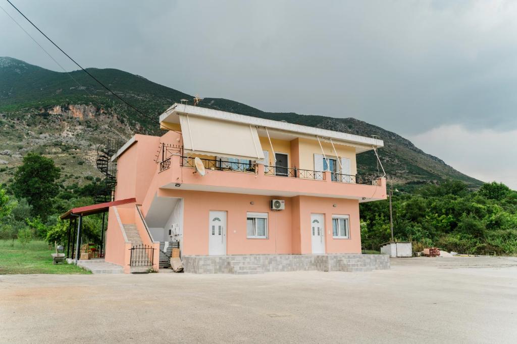 a pink house with a hill in the background at Preveza Rock Apartments in Chóïka