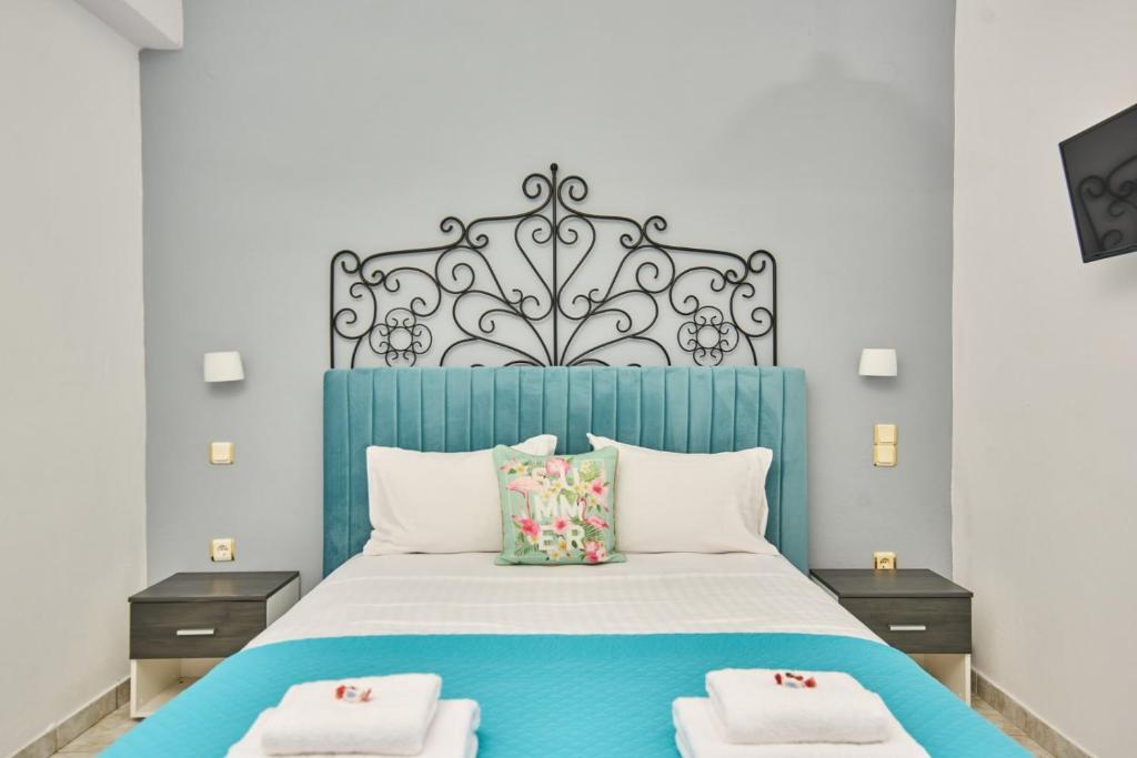 a bedroom with a blue bed with two pillows at Ostria Apartments in Kalamaki