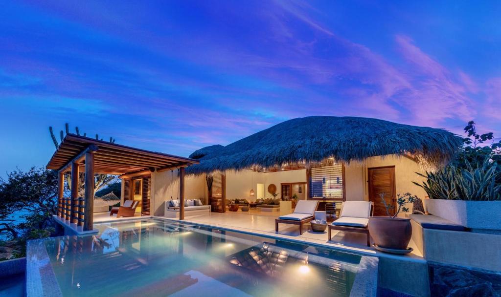 a villa with a swimming pool at night at 2071 - Villa Esquina del Cielo in Santa Cruz Huatulco