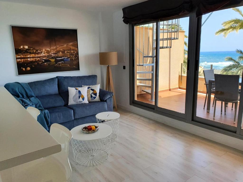 sala de estar con sofá azul y mesa en Áticos Cala Verde Playa, en Villaricos