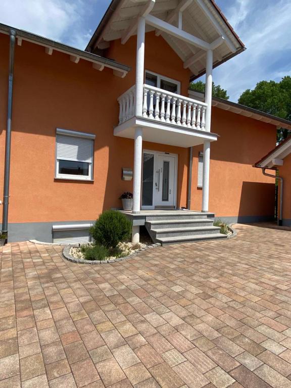 a house with a porch and stairs in a driveway at Ferienwohnung im Sand in Herbolzheim