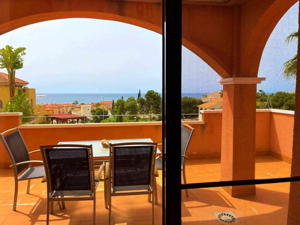 Una mesa y sillas en un balcón con vista al mar. en Sea view apartment with garden Mojon Hills, en Isla Plana