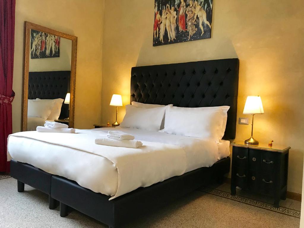 a bedroom with a large bed with a black headboard at Guest House Le Contesse in Florence