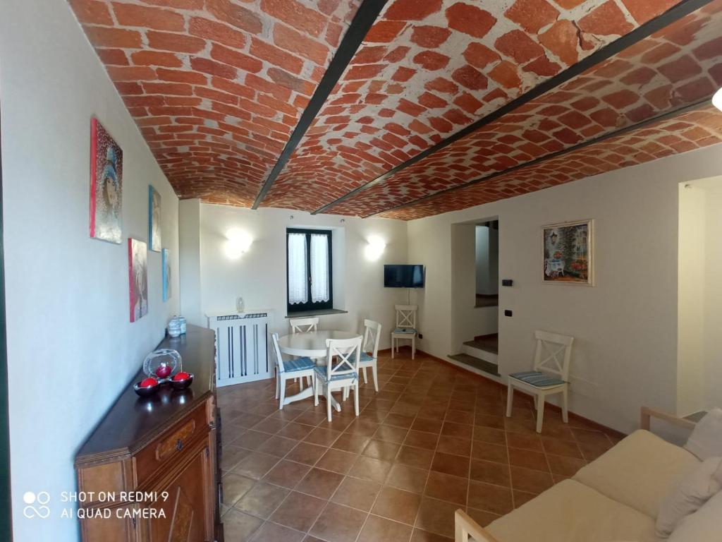 a living room with a table and a brick ceiling at B&B Il glicine in Antignano