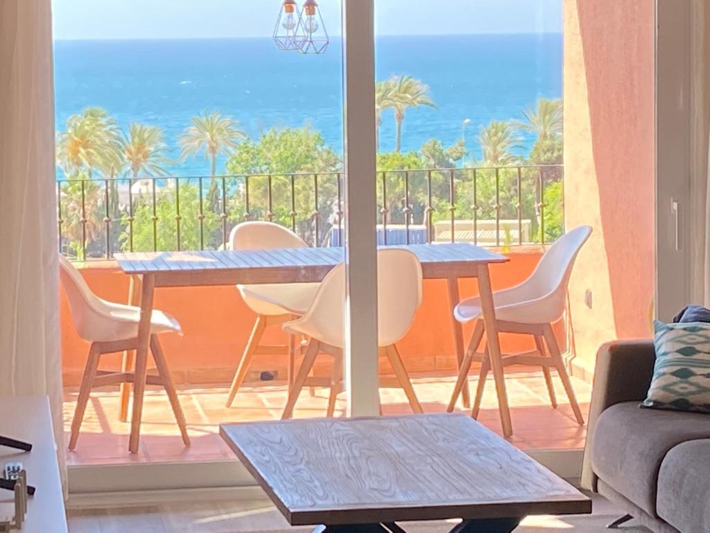 a living room with a table and a balcony with the ocean at Beautiful Penthouse apartment on Golden mile, near beach in Marbella