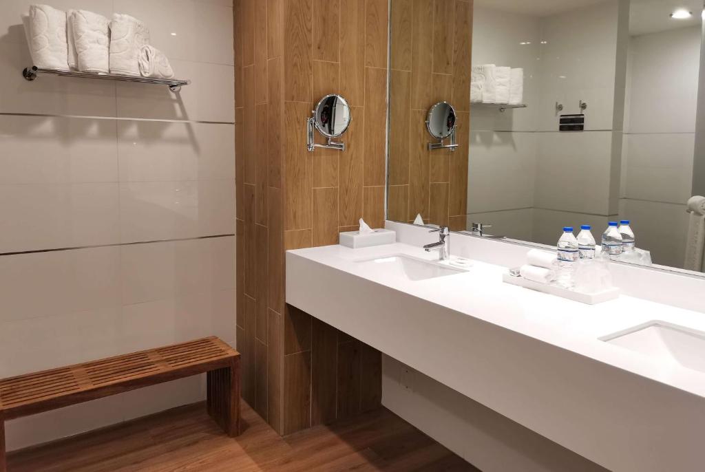 a bathroom with two sinks and a mirror at Ramada Encore by Wyndham Guadalajara Aeropuerto in Guadalajara