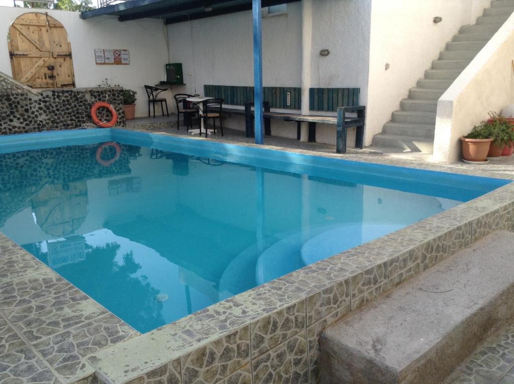 una piscina de agua azul en una casa en Rooms to let Katerina & John's, en Perissa