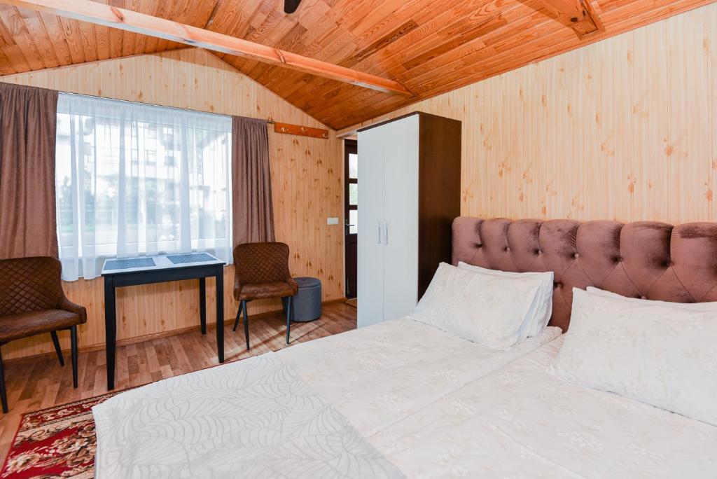 Schlafzimmer mit einem Bett, einem Schreibtisch und einem Fenster in der Unterkunft Namelio nuoma in Palanga