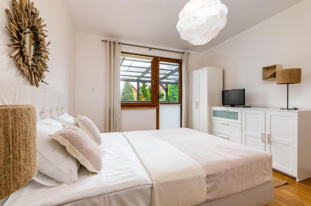 Un dormitorio blanco con una cama grande y una ventana en Ośrodek Wypoczynkowy Karolina en Stegna
