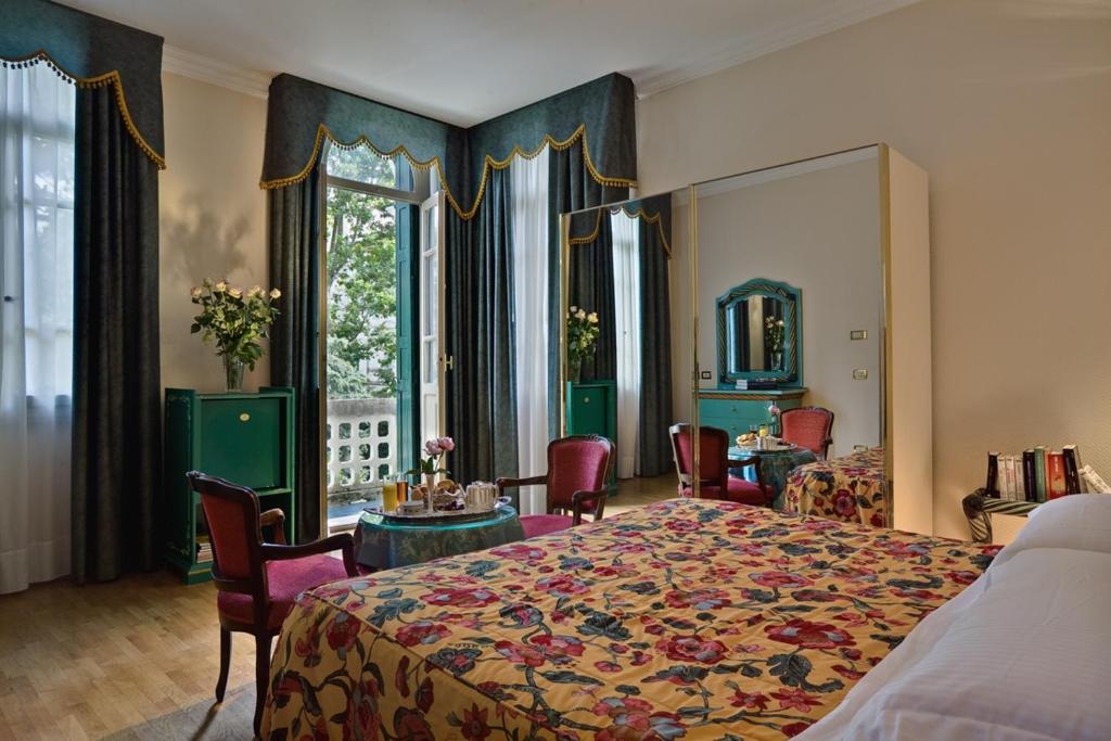 a bedroom with a bed and a table and chairs at Hotel Biasutti in Venice-Lido