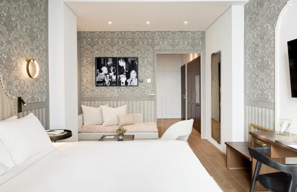a bedroom with a white bed and a living room at ON Residence - Small Luxury Hotels of the World in Thessaloniki
