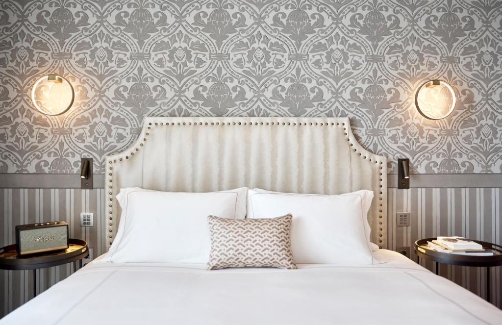 a bedroom with a white bed and a damask wallpaper at ON Residence - Small Luxury Hotels of the World in Thessaloniki