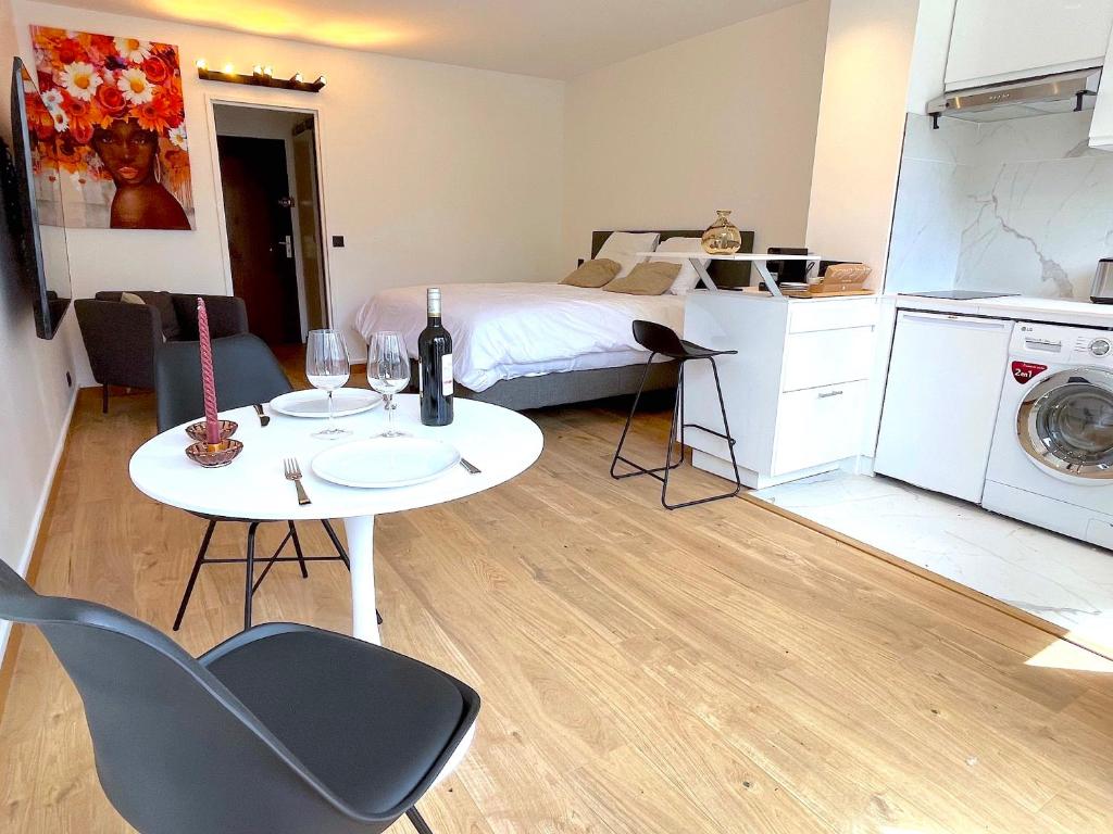 una piccola camera con letto e tavolo e una cucina di le loft 56 de Boulogne a Boulogne-Billancourt