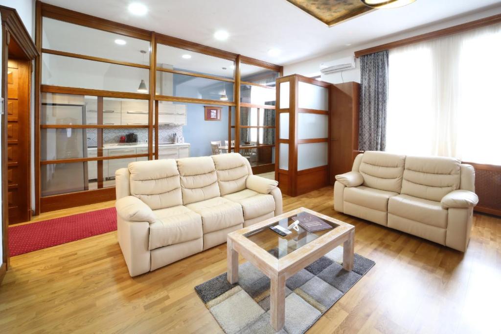 - un salon avec deux canapés blancs et une table basse dans l'établissement Virág Apartman Luxury, à Odorheiu Secuiesc