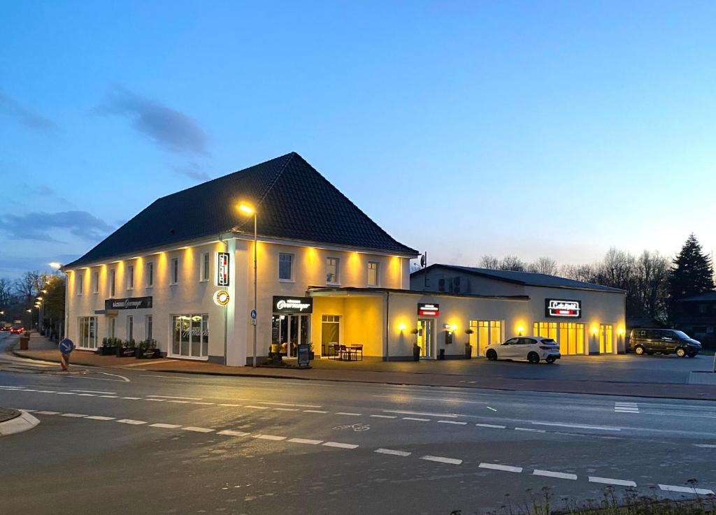 a building on a street with a car parked in front at Central Hotel Wagenfeld in Wagenfeld