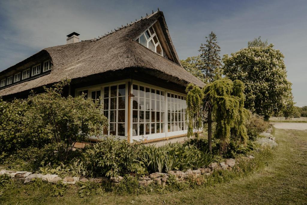 una casa con techo de paja y patio en Muhu Tõnise Talu en Liiva