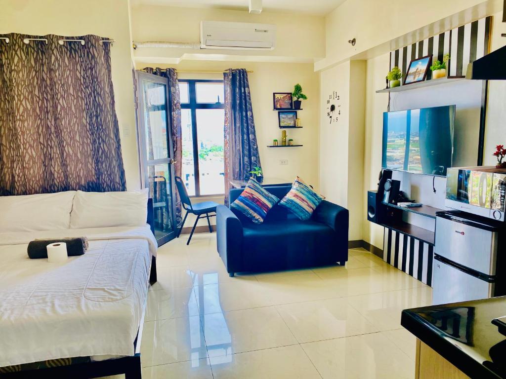 a living room with a bed and a couch at Mabolo Garden Flats Cebu in Cebu City