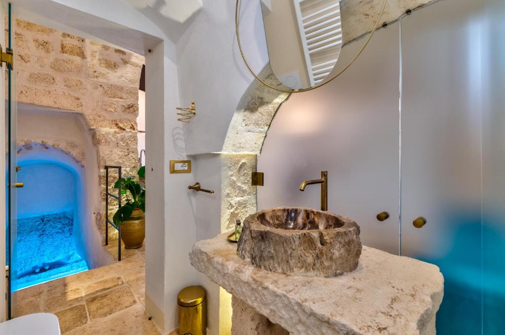 a bathroom with a stone sink in a room at AROMA luxury in Ostuni