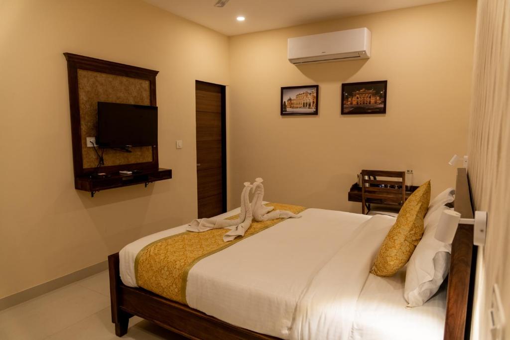 - une chambre avec un lit et une télévision dans l'établissement Vienna- A Boutique Hotel, à Jaipur