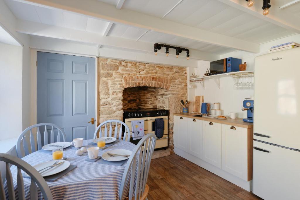 kuchnia i jadalnia ze stołem i krzesłami w obiekcie Finest Retreats - Primrose Cottage w mieście Tywardreath