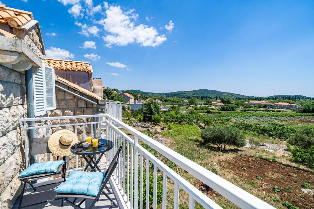 a balcony with two chairs and a table with a view at Apartments Amalija in Čilipi
