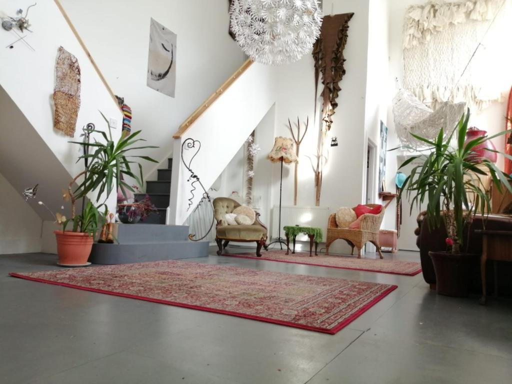 a living room with plants and chairs and a rug at Gallery Flat in Newburgh