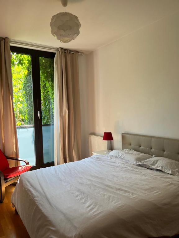 Un dormitorio con una gran cama blanca y una ventana en Apartament 2 camere Nordului, en Bucarest