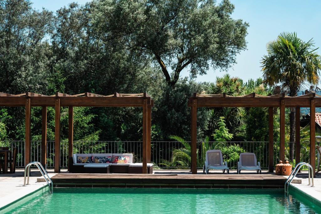 a swimming pool with two chairs and a gazebo at Casa Lata - Agroturismo e Enoturismo in Amares