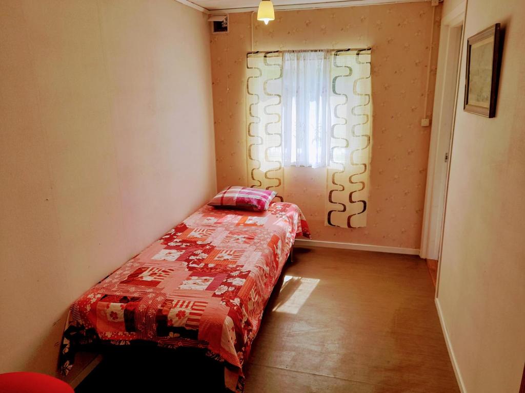 una piccola camera da letto con un letto con un piumone rosso e una finestra di Single bedroom, outside toilet, shower, kitchen. 120 m from Sandbach a Bräcke