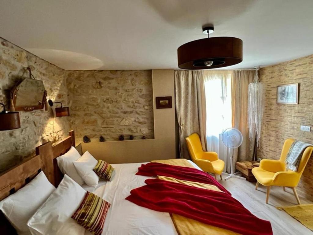 1 dormitorio con 1 cama grande y 2 sillas amarillas en Residence La Borde, en Plavilla