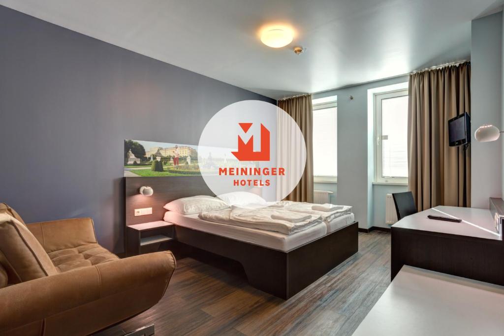 維也納的住宿－熙喜市中心梅寧閣酒店，酒店客房,设有一张床,墙上有标志