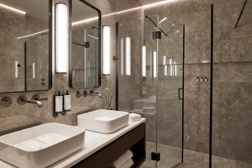 a bathroom with a sink and a glass shower at ON Residence - Small Luxury Hotels of the World in Thessaloniki