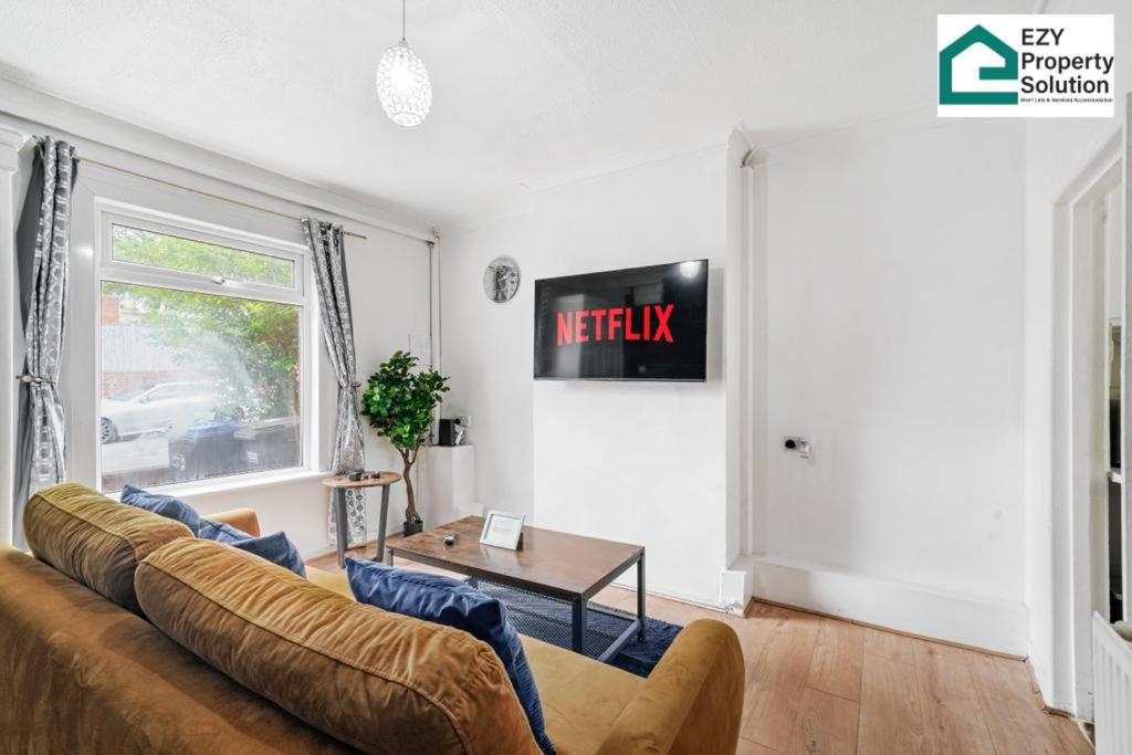 un soggiorno con divano e tavolo di Ezy Property Solution Short Lets & Serviced Accommodation Norbury a Londra