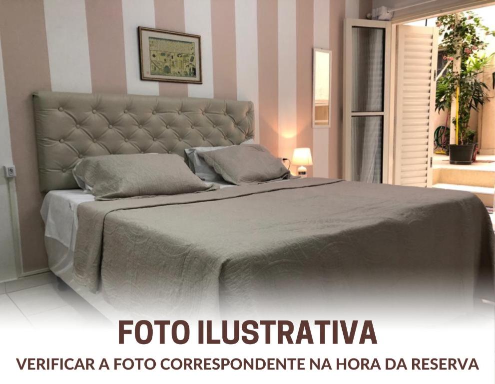 a bedroom with a large bed with a large headboard at Hostel Ipê in Sao Paulo