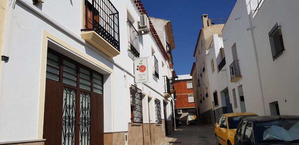 un callejón estrecho con edificios y un coche amarillo en una calle en La Casa de Asensia, en Vélez Rubio