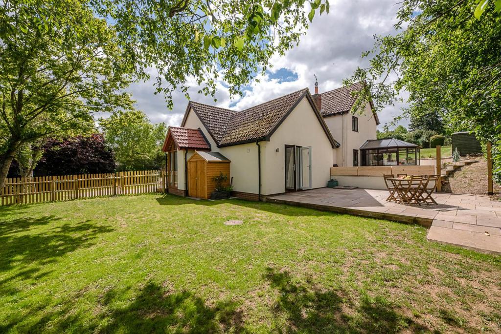 a house with a fence and a yard at Hattie's in Saxmundham