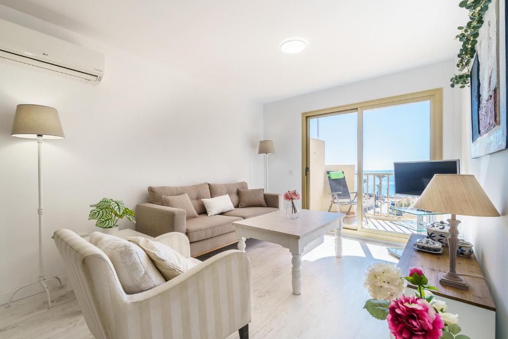 ein Wohnzimmer mit einem Sofa und einem Tisch in der Unterkunft MalagaSuite Living Coast Fuengirola in Fuengirola