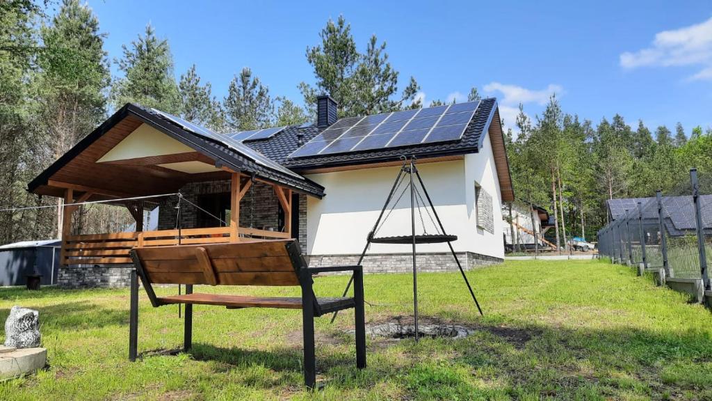 a house with a solar roof with a swing at Trzy Sosny Płaska in Płaska