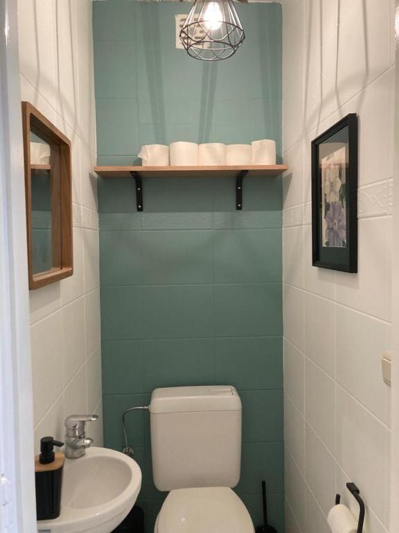 a bathroom with a white toilet and a sink at Appartement vue sur mer - Splendide localisation! in Sint-Idesbald