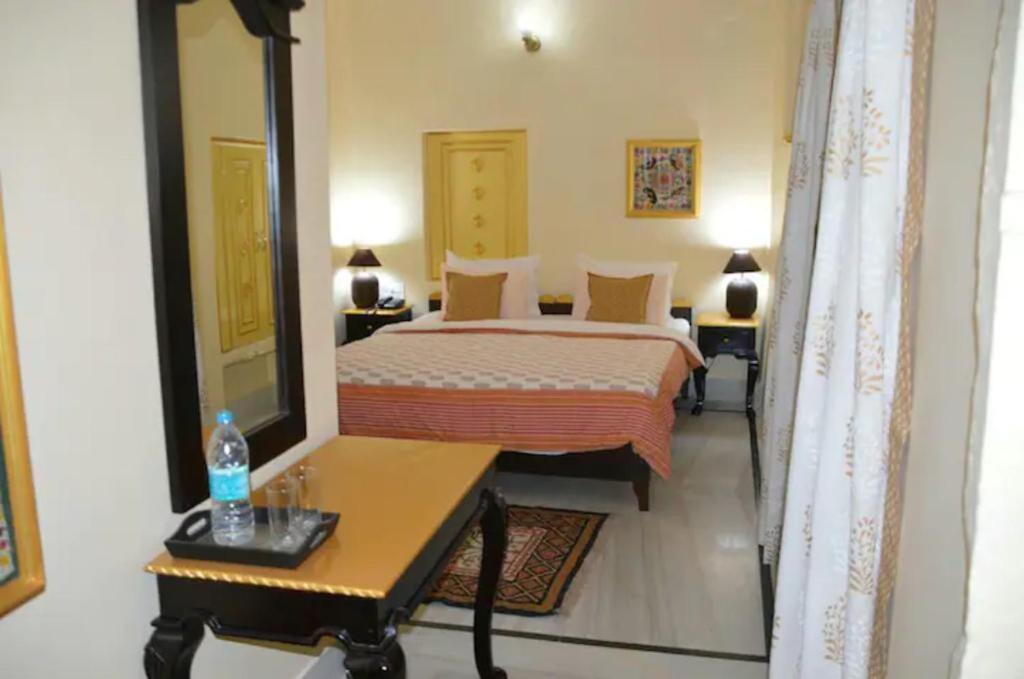 een slaapkamer met een bed en een grote spiegel bij Shining Fort in Jaisalmer
