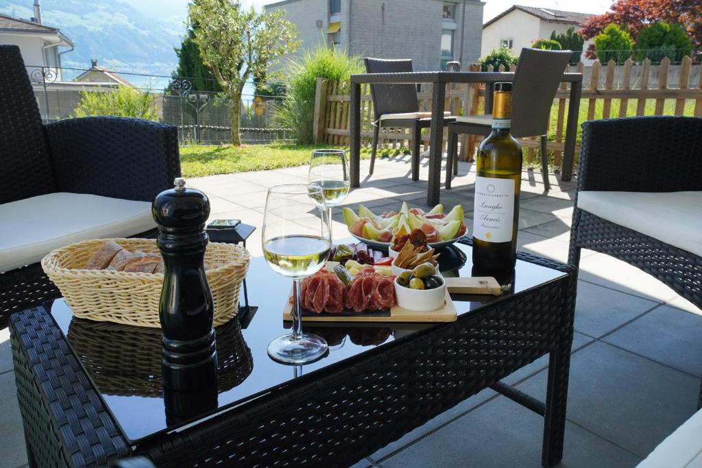 einen Tisch mit einem Teller Essen und zwei Gläsern Wein in der Unterkunft Ferienwohnung Grünegg in Gersau