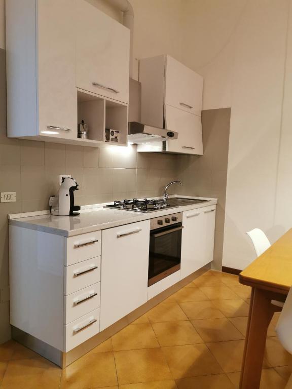 kuchnia z białymi szafkami i piekarnikiem w obiekcie Casetta "Safilu2" 1 min a piedi da M Lodi-Porta Romana w Mediolanie