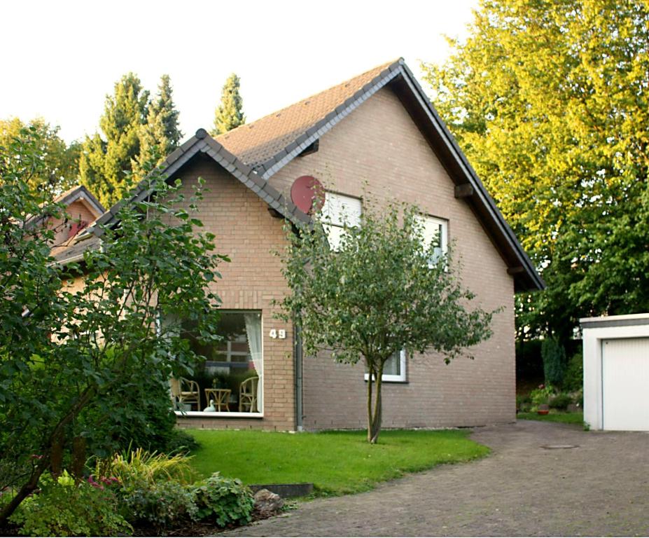 ein Backsteinhaus mit einem Baum im Hof in der Unterkunft Ferienwohnung Anna in Wermelskirchen