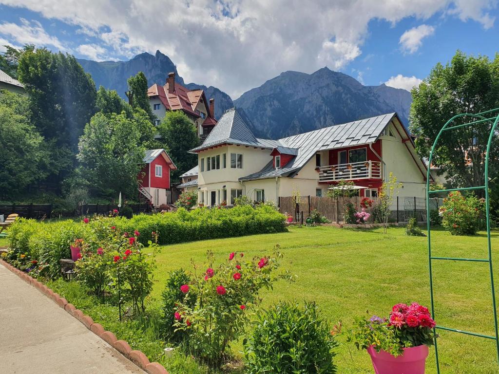 a house with a yard with flowers in front of it at Casa Turta Dulce in Buşteni