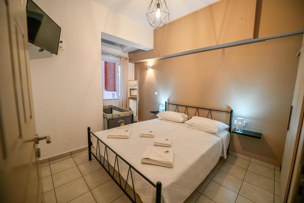 1 dormitorio con 1 cama con sábanas blancas y TV en Artemis No.2 Apartment en Kíssamos