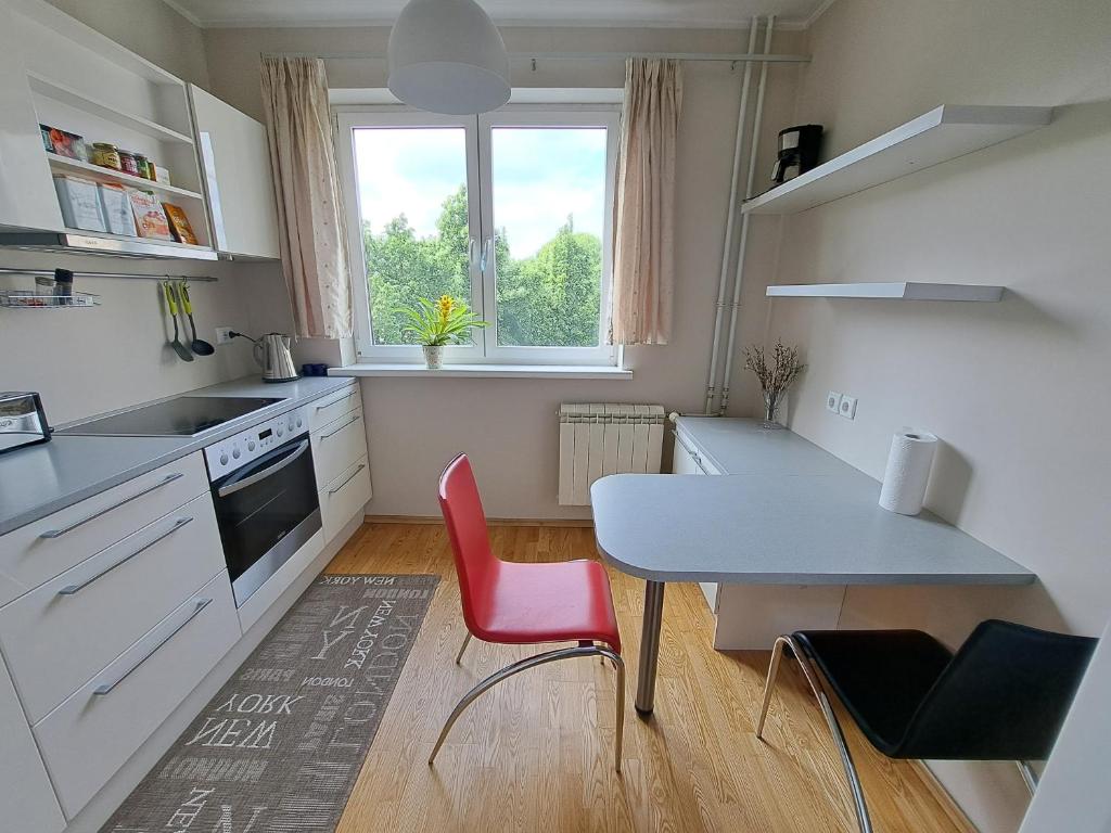 a kitchen with a table and red chairs in a room at Volvi Apartment in Tallinn