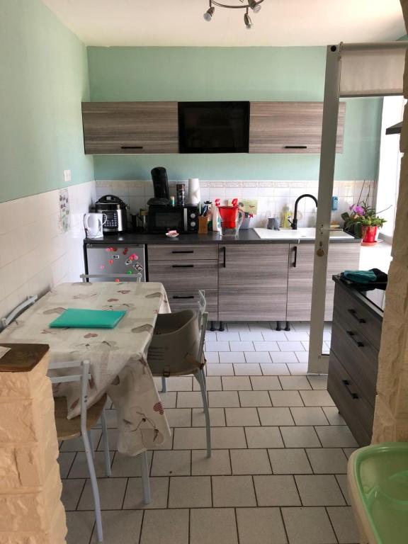 a kitchen with a table and a sink at Pied à terre in Blainville-sur-lʼEau