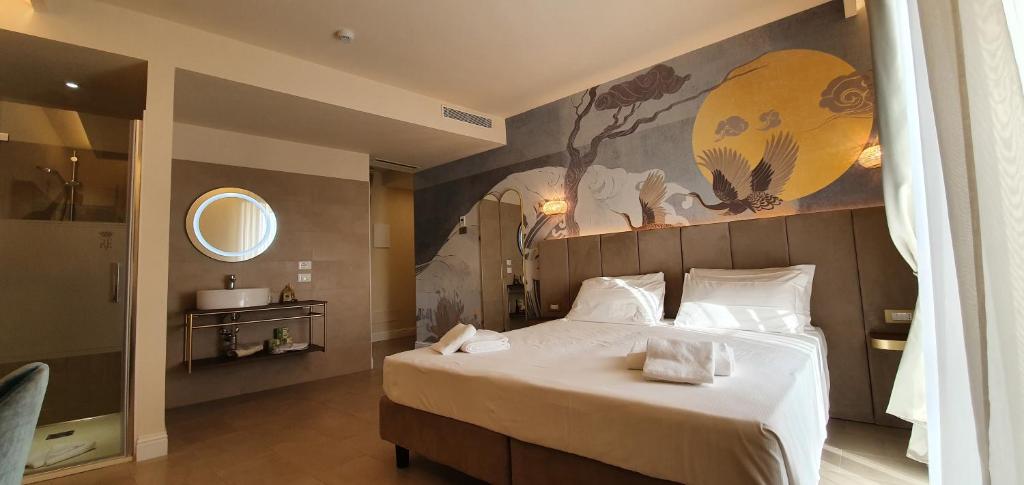 a bedroom with a large bed and a painting on the wall at I Tre Re in Bardolino