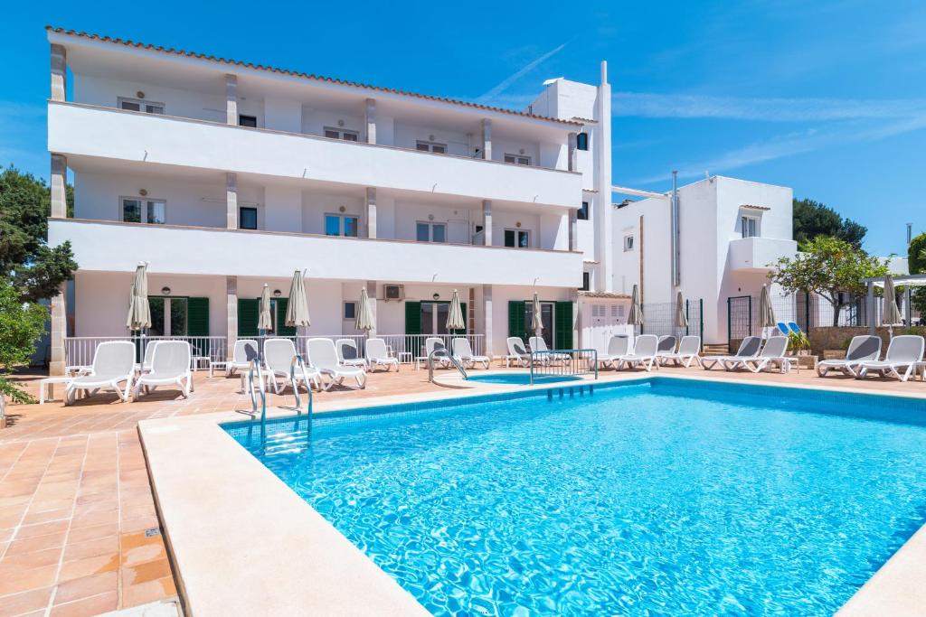 a villa with a swimming pool in front of a building at Hotel Ses Puntetes in Cala d´Or