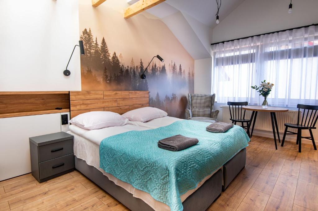 a bedroom with a bed and a table and chairs at Willa Ponikiewka in Międzybrodzie Bialskie